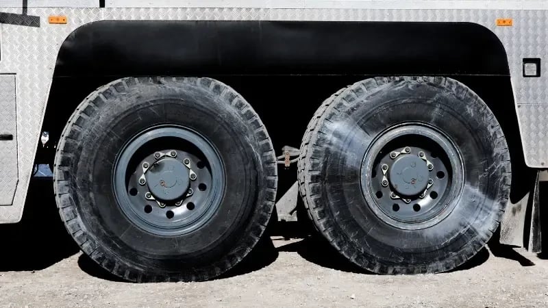 Large industrial vehicle tires looking slightly flat and deflated